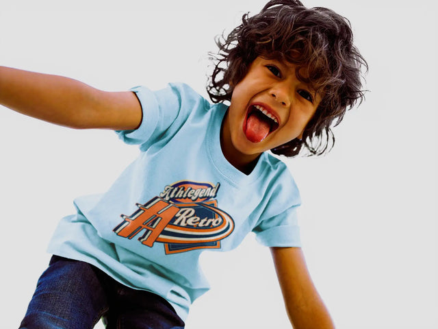 Light blue cotton t-shirt with a bold orange and navy graphic reading ’athlegend retro’ across the chest.